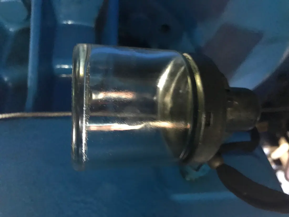Vaso lubricador de vidrio completamente vacío, sin aceite visible en su interior
